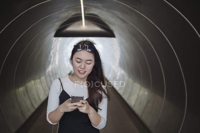 Chinese long hair woman standing in tunnel — Stock Photo