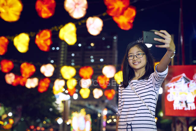 COMUNICATI Piccola ragazza asiatica scattare selfie su smartphone — Foto stock