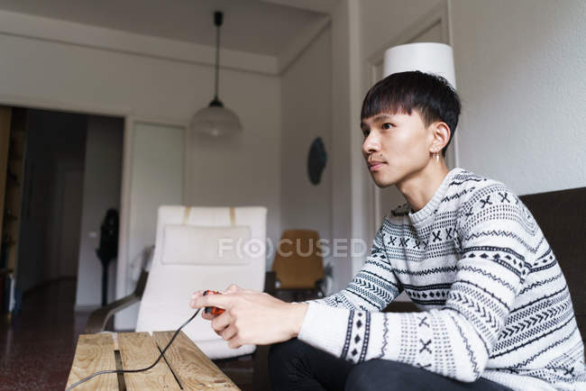 Giovane asiatico uomo giocare video giochi a casa — Foto stock