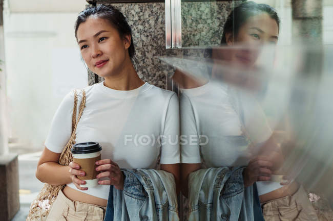Jovem atraente asiático mulher com café xícara — Fotografia de Stock