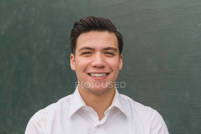 Jeune homme regardant la caméra et souriant — Photo de stock