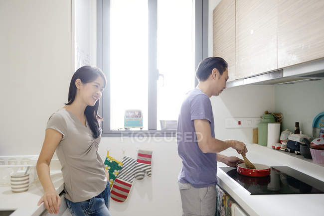 Mature asian casual couple on kitchen together, man preparing food — Stock Photo