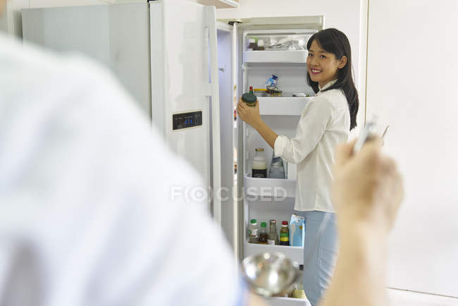 Glückliche junge asiatische Familie kocht gemeinsam in der Küche — Stockfoto