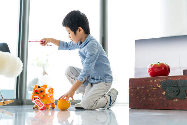 Lindo poco asiático chico jugando con juguetes - foto de stock