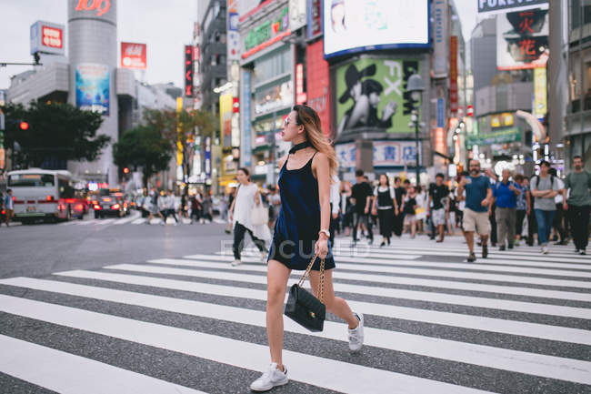 Young lady crossing the streets in Tokyo, Japan — Stock Photo