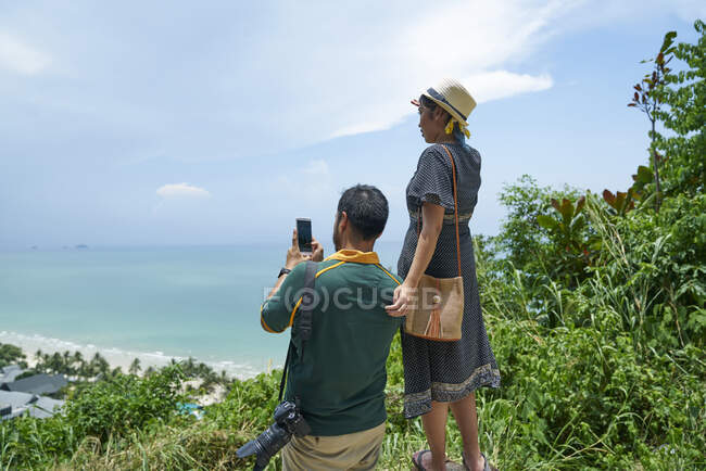 LIBERTAS Pareja joven tomando fotos del paisaje de Koh Chang en Tailandia - foto de stock