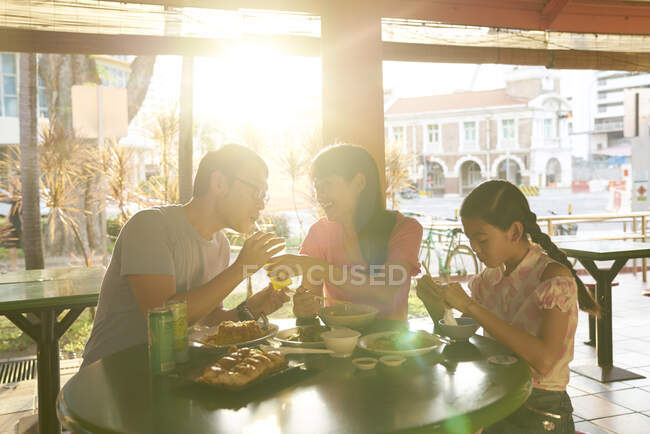 RELEASES Glückliche junge asiatische Familie isst zusammen im Café — Stockfoto