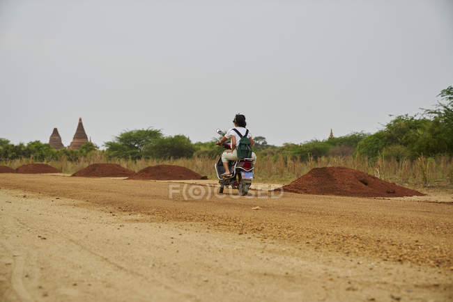 Casal jovem montando uma motocicleta juntos — Fotografia de Stock