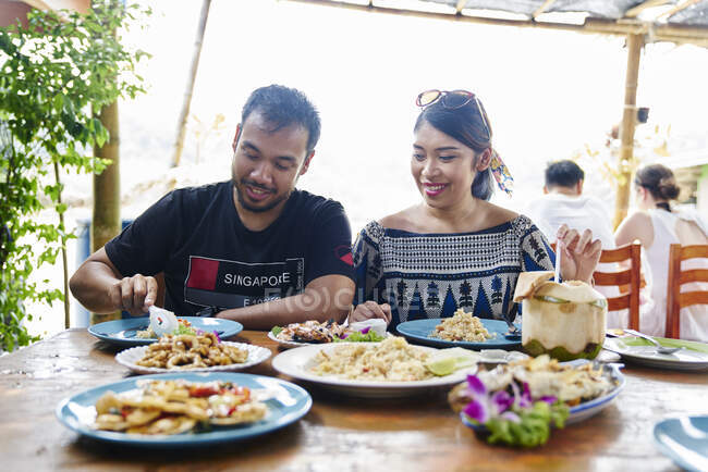 RELEASES Young couple enjoying the food in a restaurant in Koh Chang, Thailand — Stock Photo