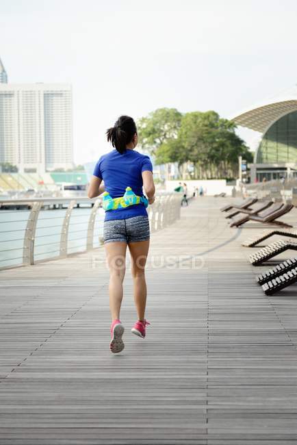Young sporty asian woman running at park — Stock Photo