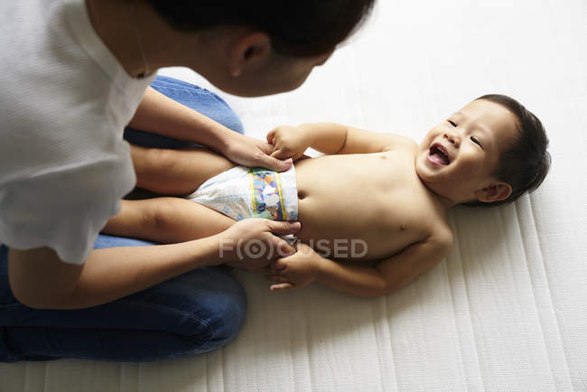 Mamma che cambia i pannolini per il suo adorabile bambino — Foto stock