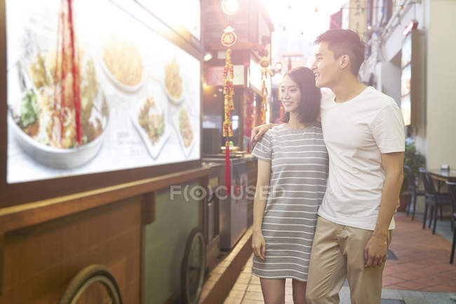 Junges asiatisches Paar shoppt im Café — Stockfoto