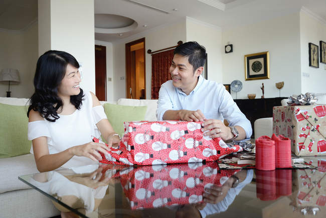 Asiático família celebrando Natal férias, casal embalagem presentes juntos — Fotografia de Stock
