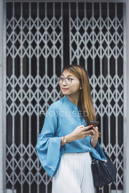 Attrayant jeune fille asiatique en utilisant smartphone — Photo de stock