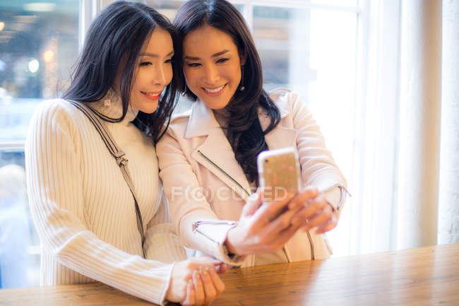 Lächelnde junge Frauen im Café — Stockfoto