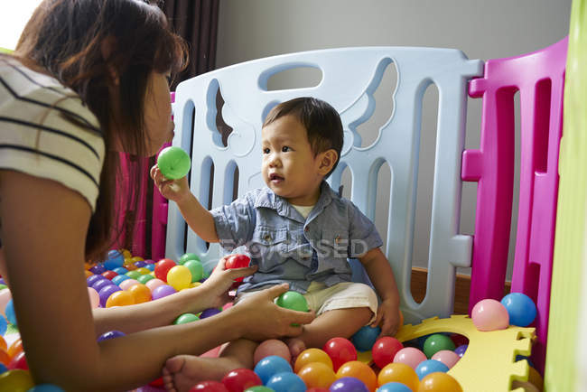 Mère collage avec bébé dans la salle de jeux — Photo de stock
