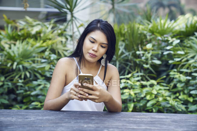 Beautiful Malay lady using her mobile — Stock Photo