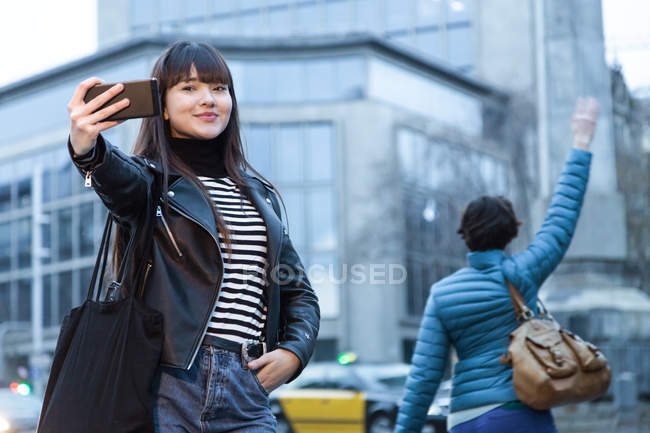 Jeune attrayant asiatique femme en ville prendre selfie — Photo de stock