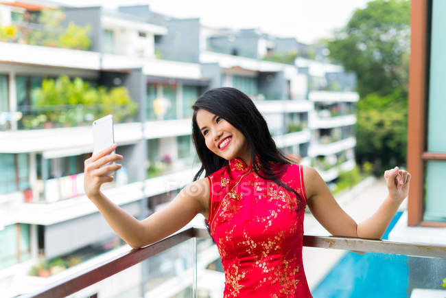 Счастливая азиатка делает селфи на смартфоне — стоковое фото