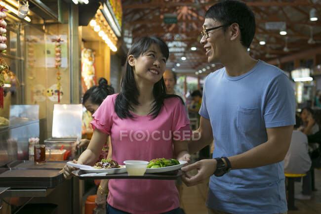 Asiático casal em conjunto com a comida no café — Fotografia de Stock