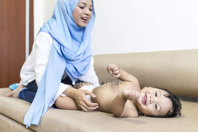 Молода азіатська мусульманська мати і дитина грають вдома — стокове фото