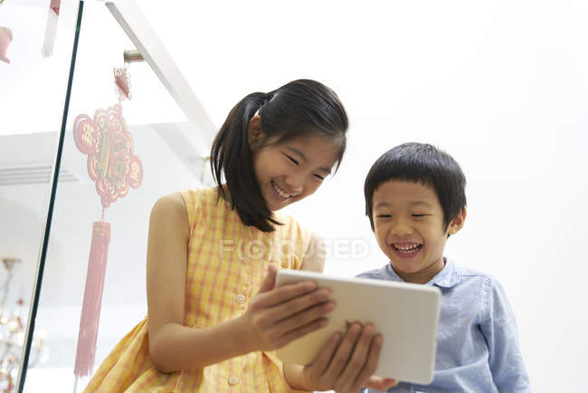 Due carino fratello e sorella insieme utilizzando tablet — Foto stock