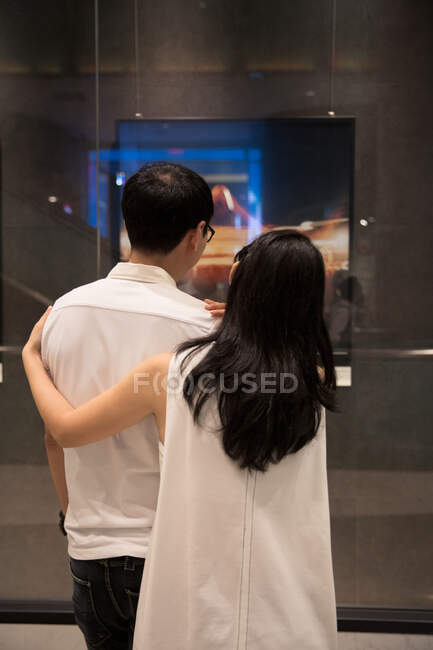 Пара захоплюється мистецькою роботою на дисплеї — стокове фото