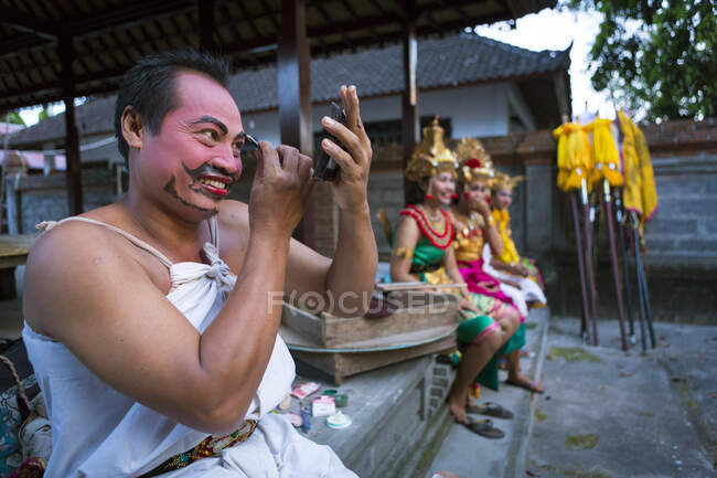 Kecak is a form of Balinese dance and music drama that developed in the 1930s in Bali.Perfomers are gutting ready in the temple and the street by putting on last touches to their Make Ups. — Stock Photo