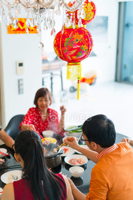 Счастливая азиатская семья, которая ест вместе за столом — стоковое фото