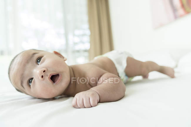Baby lying down on his tummy at home — Stock Photo