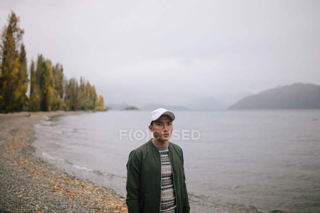 Молодой человек исследует пролив Милфорд, Новая Зеландия — стоковое фото