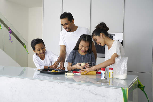 Junge asiatische Familie feiert Hari Raya gemeinsam zu Hause und kocht traditionelle Gerichte — Stockfoto