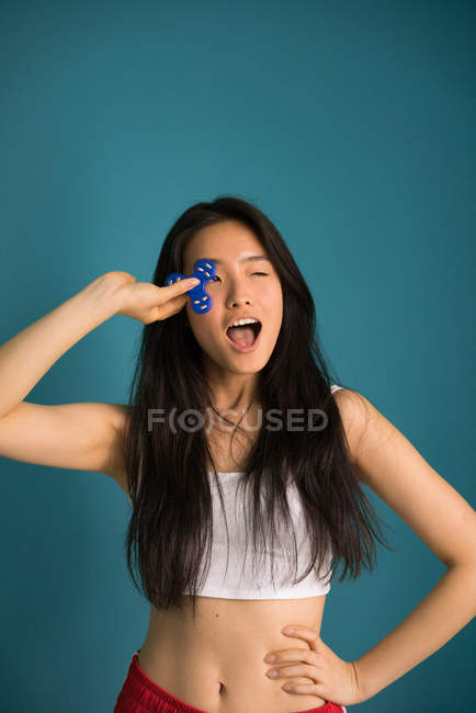 Chinesin posiert mit blauem Spinner vor der Kamera — Stockfoto