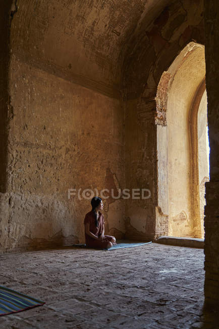 Молодая леди покоится внутри древнего храма, Пагода, Баган, Мьянма — стоковое фото