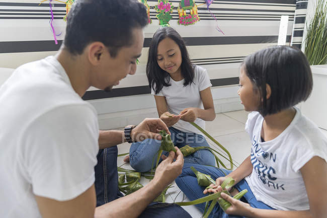 Felice famiglia asiatica che celebra hari raya a casa e prepara decorazioni — Foto stock