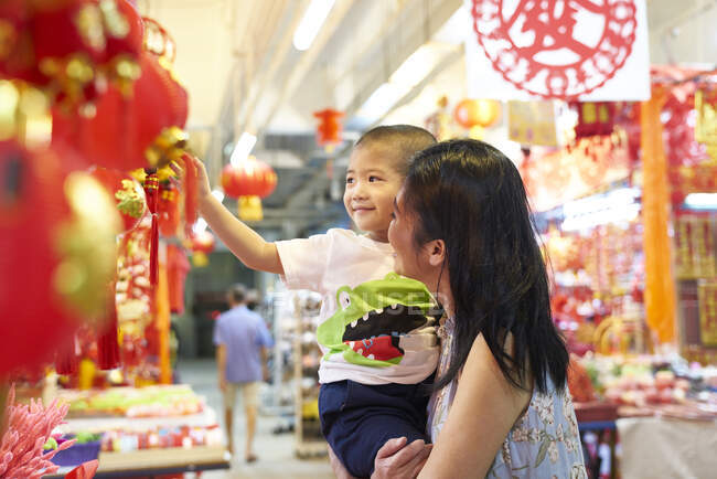 RELEASES Happy asian mother and little boy spending time together at chinese new year and shopping — Stock Photo