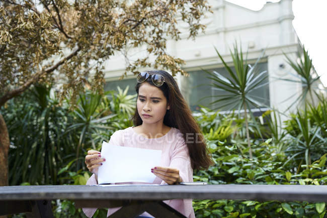 Giovane malese signora frustrato con i documenti che sta guardando attraverso — Foto stock