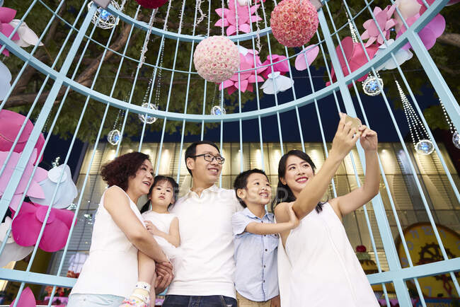 Счастливая азиатская семья проводит время вместе и делает селфи — стоковое фото