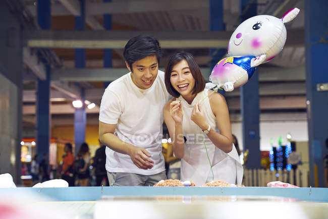 Couple tossing coins at a carnival to win prizes in Singapore — Stock Photo