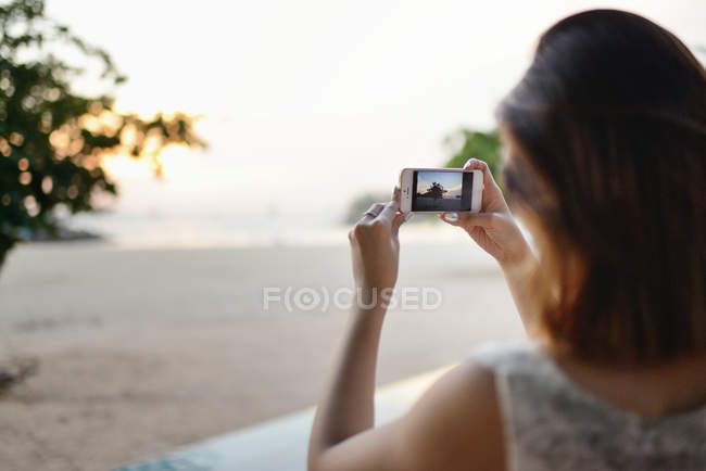 Joven atractivo asiático mujer tomando foto en la naturaleza - foto de stock
