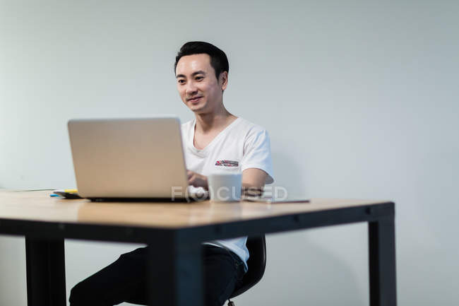 Молодой азиат, работающий в современном офисе — стоковое фото