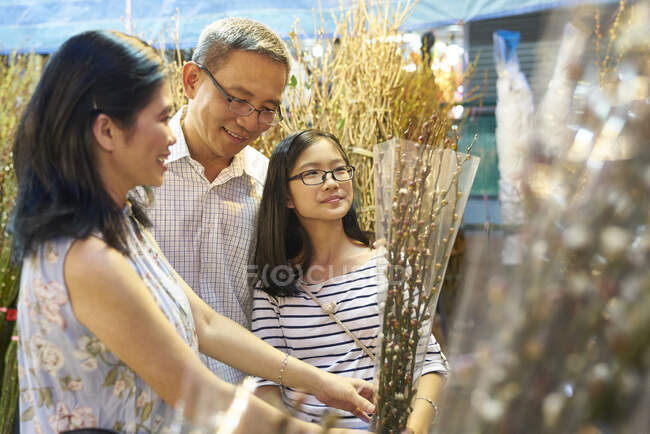 RELEASES Happy asian family spending time together at chinese new year in market — Stock Photo