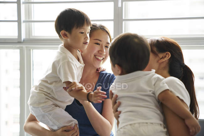 Giovani madri che legano con i loro figli in soggiorno — Foto stock