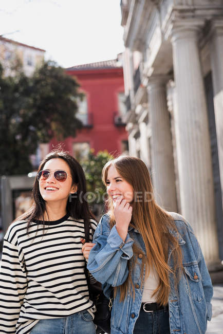 Dos hermosas amigas caminando por la ciudad - foto de stock