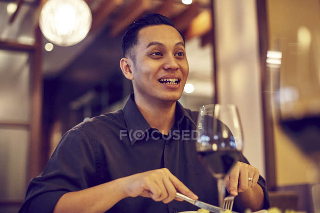 Young asian handsome man in cafe with wine — Stock Photo