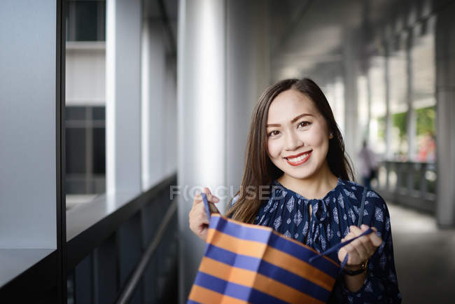 Щаслива красива азіатська жінка в магазинах з покупками — стокове фото