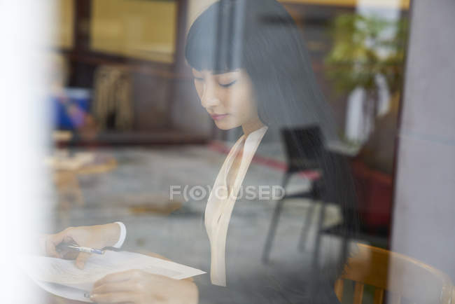 Junge attraktive asiatische Geschäftsfrau arbeitet im Café — Stockfoto