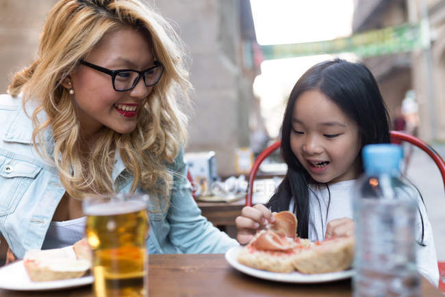Счастливая молодая блондинка с дочкой завтракают . — стоковое фото