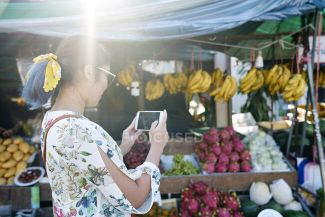 RELEASES Young woman taking photos of a street fruit stall in Koh Chang, Thailand — Stock Photo