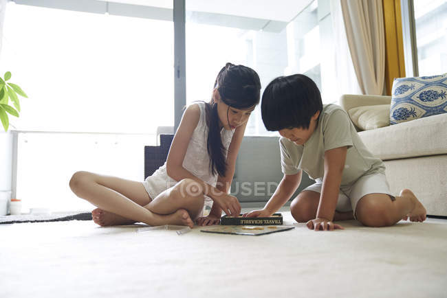Feliz joven asiático familia juntos, niños jugando scrabble en casa - foto de stock
